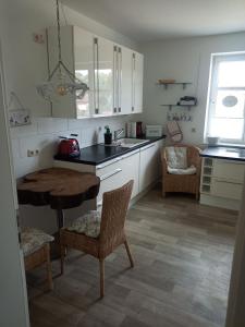 een keuken met witte kasten en een tafel en stoelen bij Lausitzer Auszeit in Laubusch