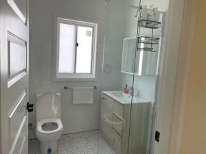 a white bathroom with a toilet and a window at Heart of Katoomba Semi 1 bedroom home in Katoomba