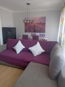 a purple couch with white pillows in a living room at Casa do Zé in Setúbal