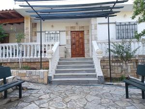 un escalier menant à une maison avec une porte en bois dans l'établissement Ktima Gardenyard, à Artemi