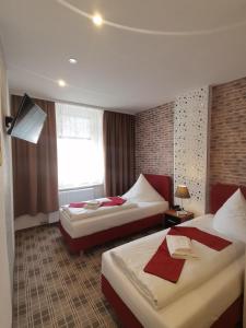 a hotel room with two beds and a window at Boulevardhotel Sängerstadt - alle Zimmer klimatisiert in Finsterwalde