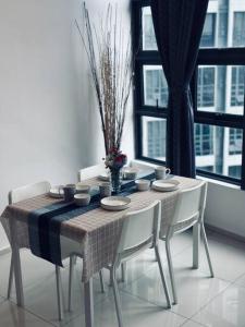 einen Esstisch und Stühle mit einem Tisch und einem Fenster in der Unterkunft EkoCheras 5-6pax Loft unit above shopping mall 2min to Mrt in Kuala Lumpur