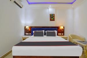 a bedroom with a large bed and two chairs at Rohini Hills in Punalūr