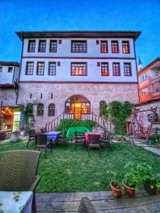 um grande edifício com um quintal com cadeiras em Muhsin Bey Konağı em Saframbolu