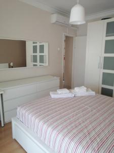 a white bedroom with a bed and a mirror at Casa do Zé in Setúbal
