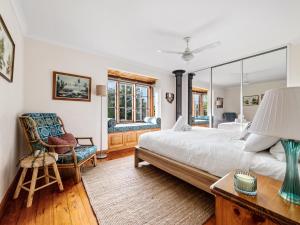 a bedroom with a large bed and a chair at Beachfront Bliss, waterfront Geographe bay in Busselton