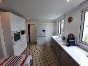 a small kitchen with white cabinets and appliances at Maison Anglet, 7 pièces, 11 personnes - FR-1-239-860 in Anglet