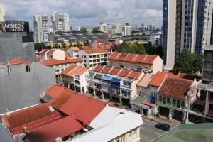 a group of buildings with red roofs in a city at Aqueen Prestige Hotel Jalan Besar in Singapore