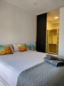 1 cama blanca grande con 2 almohadas encima en Apartamento El Hidalgo, en Alcalá de Henares