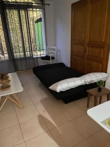 a room with a bed and a table and a window at Charmant logement proche de la mer in Florensac