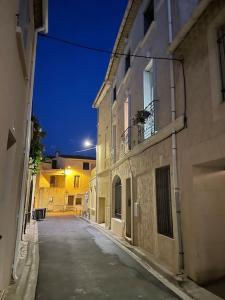 an empty street at night next to a building at Charmant logement proche de la mer in Florensac