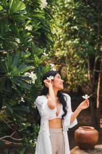 a woman is standing in front of a tree at Kooncharaburi Resort - Koh Chang in Ko Chang