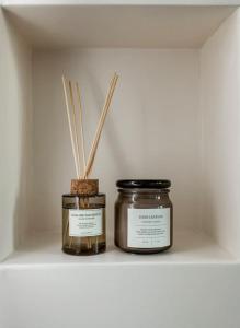 two jars sitting on a shelf with sticks at Appartement spa : O'Spa Zen Jacuzzi-Sauna-Terrasse in Ivry-sur-Seine