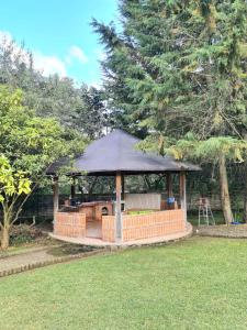 un cenador con una sombrilla negra en un patio en Hermoso Glamping en Quinta Privada, en Quito