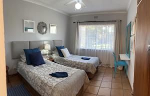 a hotel room with two beds and a window at Sabie Self Catering Apartments in Sabie