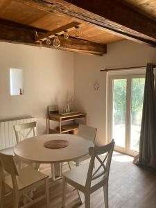 ein Esszimmer mit einem Tisch, Stühlen und einem Fenster in der Unterkunft Maison, Le Champ du Rossignol in Beuvron-en-Auge