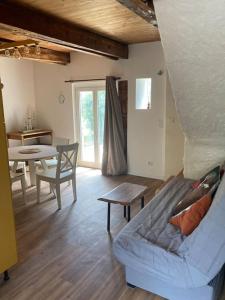 ein Wohnzimmer mit einem Sofa und einem Tisch in der Unterkunft Maison, Le Champ du Rossignol in Beuvron-en-Auge