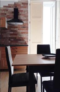 uma sala de jantar com uma mesa de madeira e cadeiras em Il Pilone em Barletta