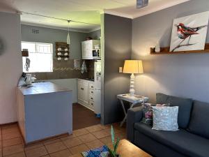 a living room with a couch and a kitchen at Sabie Self Catering Apartments in Sabie