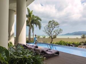 una persona in piedi accanto alla piscina di un resort di Luxury Sea View Apartment a Nha Trang