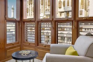 a living room with windows and a couch and a table at Jumeirah Jabal Omar Makkah in Mecca