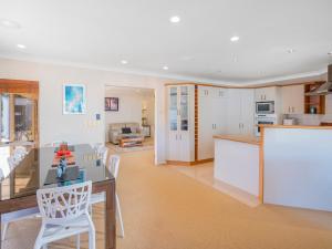 a kitchen and living room with a table and chairs at Sunset View - Pauanui Waterfront Home in Pauanui