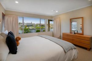 a bedroom with a large bed and a large window at Sunset View - Pauanui Waterfront Home in Pauanui
