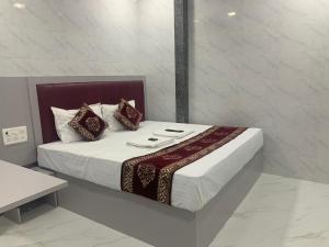 a bedroom with a large bed with red pillows at Hotel Sai Plaza, Chembur Mumbai in Mumbai
