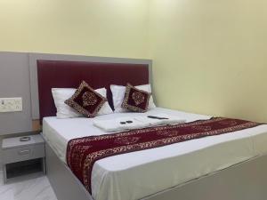 a bedroom with a large bed with red and white pillows at Hotel Sai Plaza, Chembur Mumbai in Mumbai