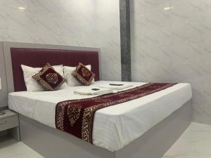 a bed with white sheets and pillows in a room at Hotel Sai Plaza, Chembur Mumbai in Mumbai