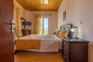 a bedroom with a bed and a dresser and a window at sparrow apartment (Σπουργιτης) in Skoulikádhon