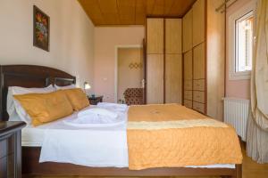 a bedroom with a bed with white sheets and an orange blanket at sparrow apartment (Σπουργιτης) in Skoulikádhon