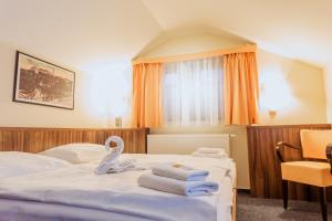 1 dormitorio con 1 cama con toallas en Hotel Studanka en Rychnov nad Kněžnou