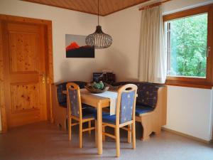d'une salle à manger avec une table, des chaises et une fenêtre. dans l'établissement Haus Baleisa, à Gaschurn