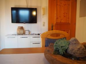 Il comprend une cuisine avec une télévision murale et une table. dans l'établissement Haus Baleisa, à Gaschurn