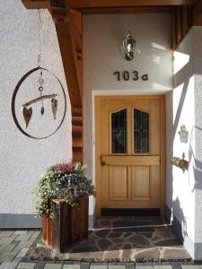 une porte d'entrée d'une maison munie d'un panneau. dans l'établissement Haus Baleisa, à Gaschurn