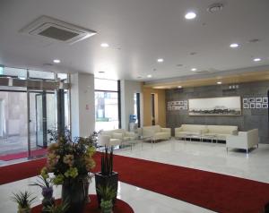 um átrio com uma sala de espera com sofás e flores em Healthcare Town Resort em Seogwipo