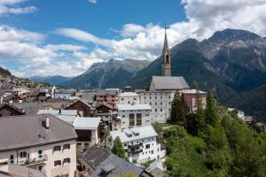 a view of a town with a church and mountains at Loft 3 in Sent