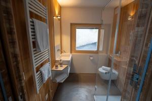 a bathroom with a toilet and a sink and a window at Chasa Loft 3 in Sent