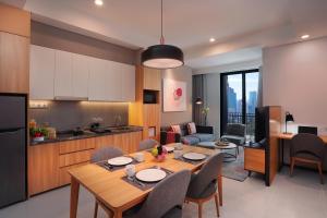 a kitchen and a living room with a table and chairs at Citadines Gatot Subroto Jakarta in Jakarta