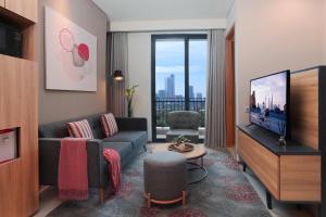 a living room with a couch and a tv at Citadines Gatot Subroto Jakarta in Jakarta