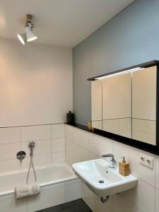 Un baño blanco con lavabo y espejo. en COAST HOUSE Seaside Loft, en Bremerhaven 43 fotos más