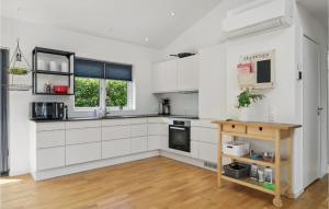 une cuisine avec des placards blancs et une table en bois dans l'établissement Beautiful Home In Glostrup With Wifi And 3 Bedrooms, à Glostrup