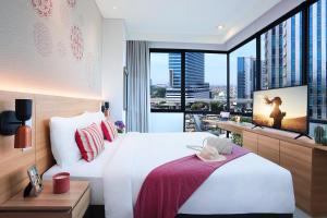 a hotel room with a bed and a large window at Citadines Gatot Subroto Jakarta in Jakarta