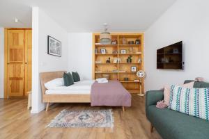 een woonkamer met een bed en een bank bij Stare Podgórze Śliska Apartment Cracow by Renters in Krakau