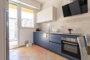 a kitchen with blue cabinets and a large window at Italian Experience-My Florence City Apartment in Florence