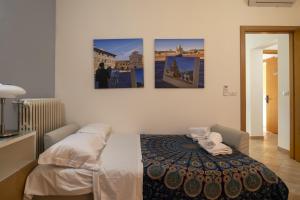 a bedroom with a bed with three paintings on the wall at Italian Experience-My Florence City Apartment in Florence