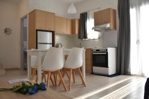 a kitchen with white chairs and a white stove top oven at Ble Island in Hersonissos