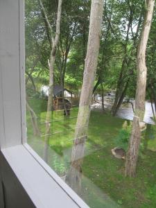 ein Fenster mit Blick auf einen Garten mit Bäumen in der Unterkunft Summerhome in Skulte