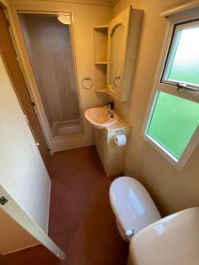 a bathroom with a toilet and a sink and a window at Nature&Rest in Łąck